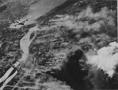 Kłęby dymu nad Policami, 20 czerwca 1944 roku. W tle widać jeden z bombowców 8-mej Armii Powietrznej. Widać również zadymianie, w tym wiele stanowisk przy działach obrony przeciwlotniczej przy nieistniejącej dziś wsi Raduń (niem. Schwabach), po lewej stronie kadru. Zabudowania silnej baterii przeciwlotniczej istnieją do dziś.