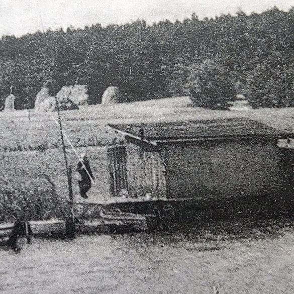 Zbliżenie na chatkę rybaka (?) na jeziorze Bartoszewo, w tle snopy siana